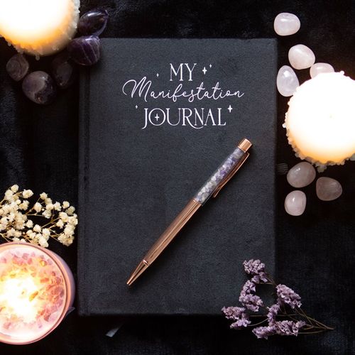 Black velvet manifestation journal with amethyst crystal chip ballpoint pen, featuring lined pages and the phrase "I write with intention to manifest my dreams."